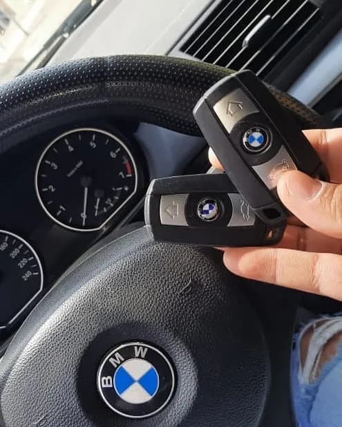Duas chaves de BMW, a original e a cópia, diante do volante