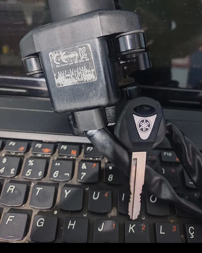 Chave de moto Yamaha ao lado do módulo de ignição, em cima do teclado do notebook